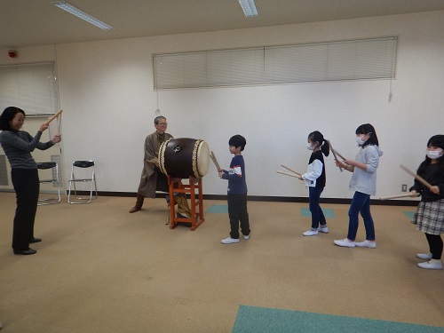 写真:大沢先生と一緒に太鼓をたたく様子