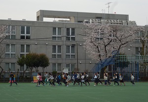 写真:校庭の桜の前をランニング