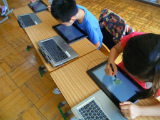 写真:タブレットPCで勉強する子ども
