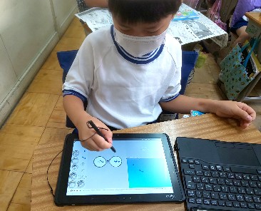 写真:タブレット画面をタッチペンで操作する様子