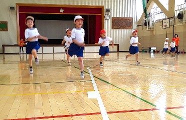 写真:体育館を走る子どもたち