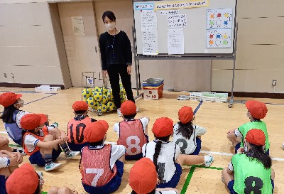 写真:ボールゲームの説明を聞く子どもたち
