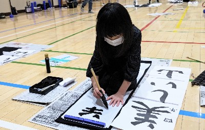 写真:体育館の床に新聞紙を広げてその上で書いている様子2