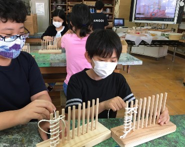 写真:縄文時代と同じ製法で漁網を編む様子2