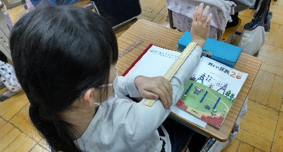 写真:30cmのものさしを使って腕をはかる様子