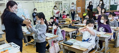写真:先生の両腕を広げた長さをはかる様子