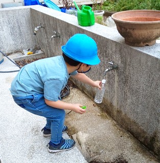 写真:ペットボトルに水を入れている様子