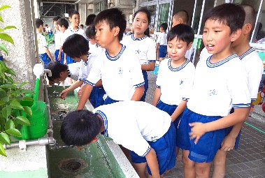 写真:水を飲む子どもたち