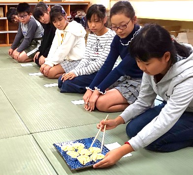 写真:茶道　主菓子を懐紙にとる様子