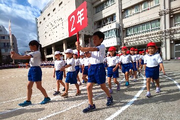 写真:運動会全体練習　プラカードを持つ児童