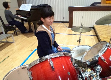 写真:「まくをあけよう」ドラムをたたく児童2