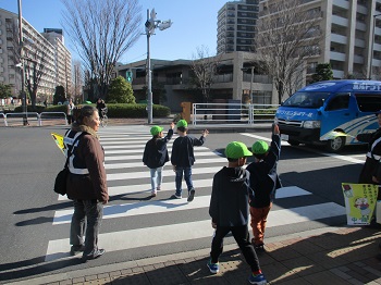 写真:手をあげて横断歩道を渡る子どもたち