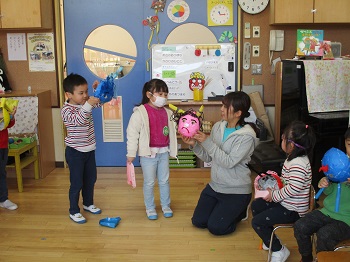 写真:鬼のお面を持つ先生と子どもたち