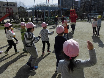 写真:外で鬼に向かって豆まきをする子どもたち