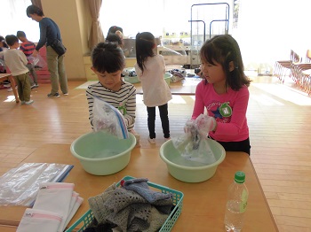 写真:ビニールの袋をもむ子どもたち