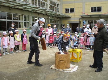 写真:大人の餅つきを見ている子どもたち