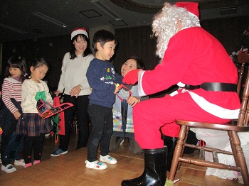 写真:サンタさんからプレゼントをもらう子どもたち