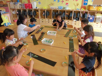 写真:テープとハサミで制作する子どもたち