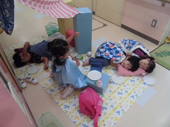 写真:室内で寝転んで遊ぶ子どもたち