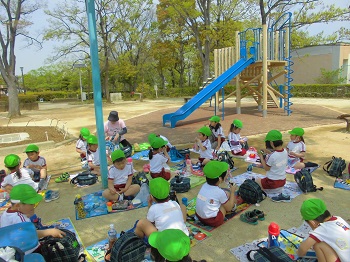 写真:青空の下でお弁当を食べる子どもたち