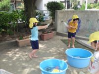 写真:友達と水遊びをする子ども