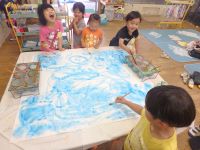 写真:青色で絵を描く子どもたち