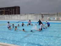 写真:プールで輪になって遊ぶ先生と子どもたち