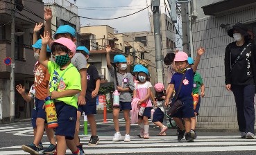 写真:手を挙げて歩く子どもたち