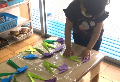 写真:折り紙で菖蒲を作る子ども