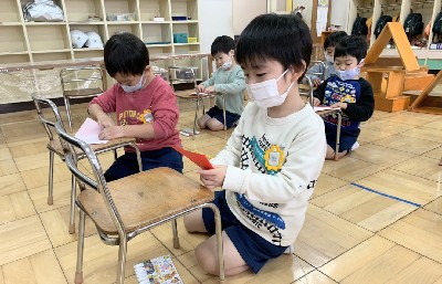 写真:折り紙でサンタさんを折る子どもたち