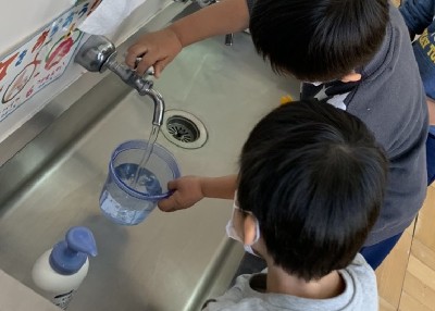 写真:容器に水を入れる子どもたち