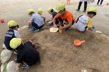 写真:友だちと集まって化石探しをする子どもたち