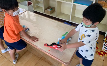 写真:空き箱で車を作る子どもたち