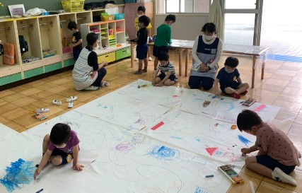 写真:大きな紙に絵を描く子どもたち