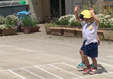 写真:手をあげて歩く子どもたち