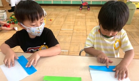 写真:折り紙で蝶々を折る子どもたち
