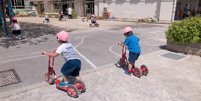 写真:三輪車やスクーターで遊ぶ子どもたち