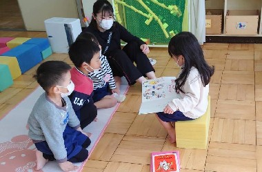 写真:お友だちに絵本を読んであげる子ども