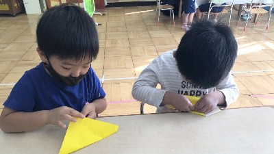 写真:三角折りできつねを作る子どもたち