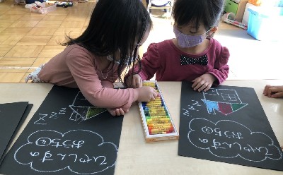 写真:クレヨンで絵を描く子どもたち