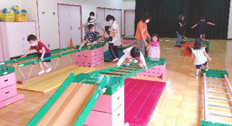 写真:遊園地で喜んで遊ぶ子どもたち