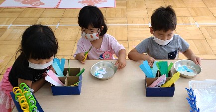 写真:ハサミを使って制作する子どもたち