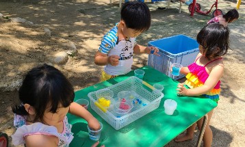 写真:戸外で色水遊びをする子どもたち2