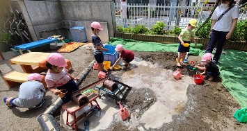 写真:園庭で水遊びをする子どもたち