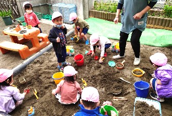 写真:初めての砂場遊びをする子どもたち