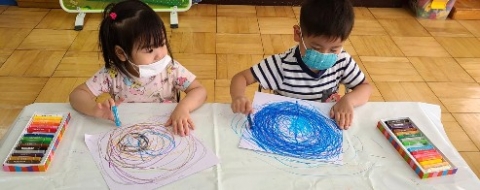 写真:お絵描きする子どもたち