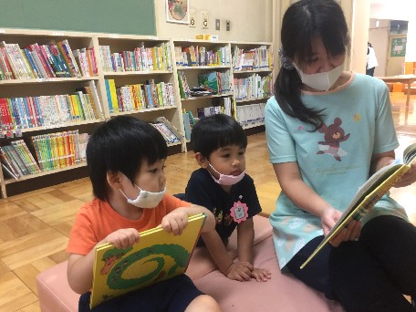 写真:先生と絵本を読む子どもたち