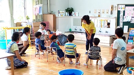 写真:もも組　先生の話をいすに座って聞く子どもたち