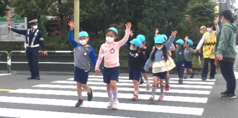 写真:手をあげて横断歩道を渡る子どもたち