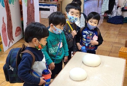 写真:成形したお餅を見る子どもたち